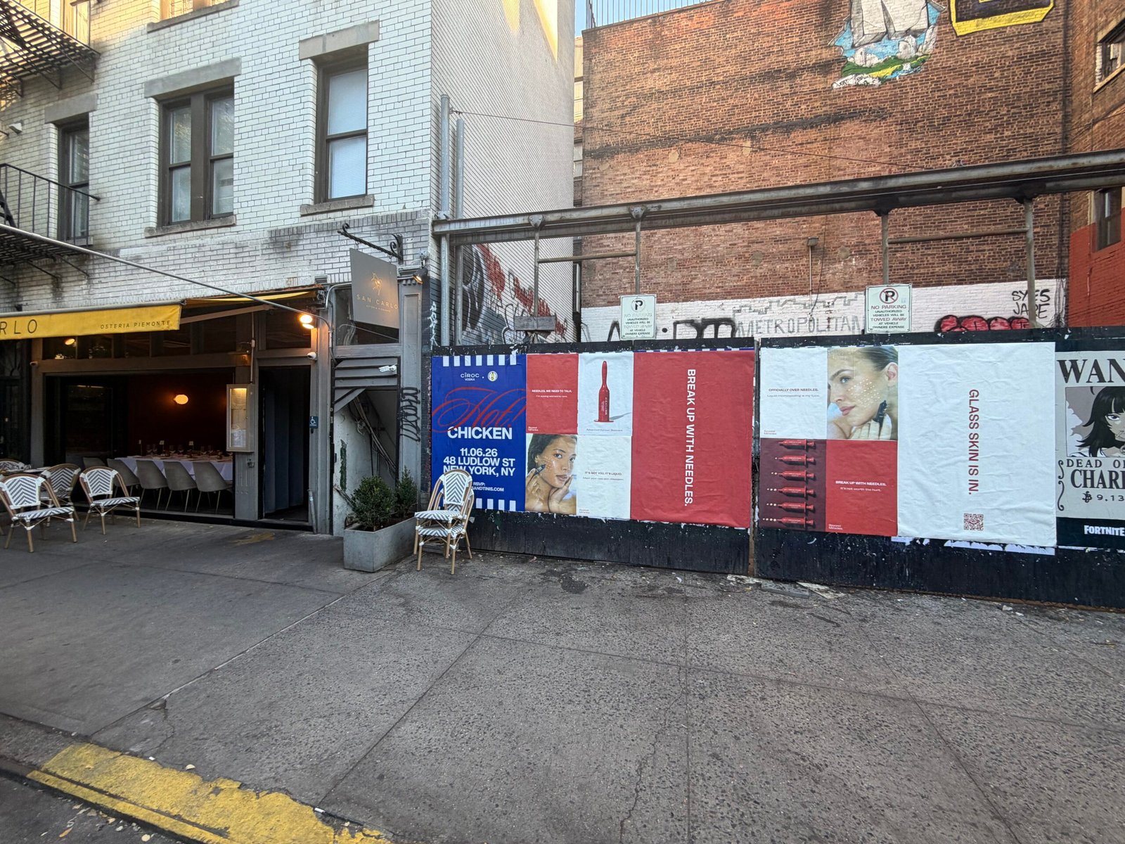 Angled street view of the Beyond Miracles skincare poster display beside a restaurant