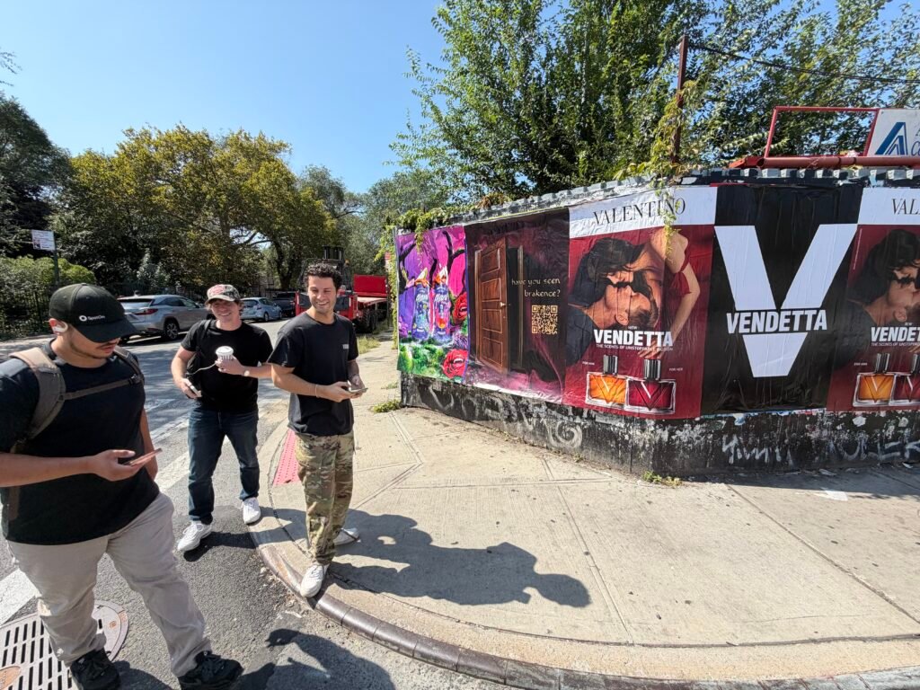 People beside a street poster display with QR-code and Valentino artwork