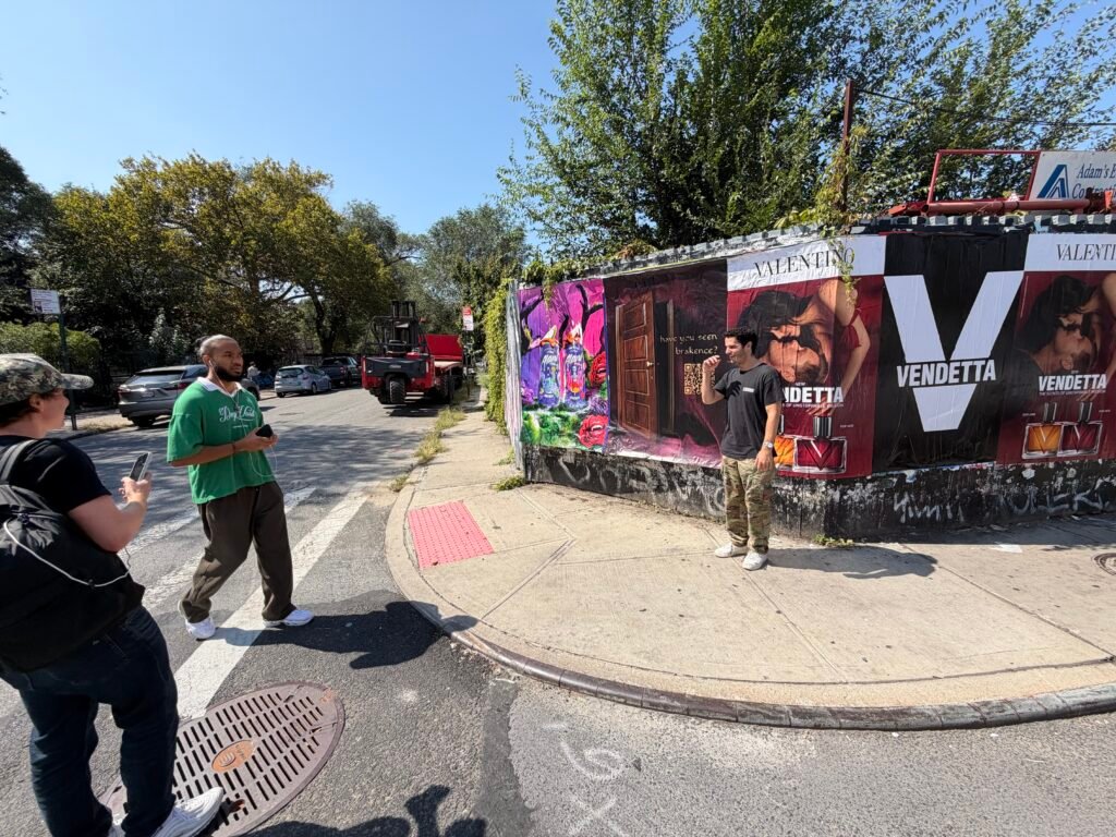 Street-level view of people beside a repeated poster display
